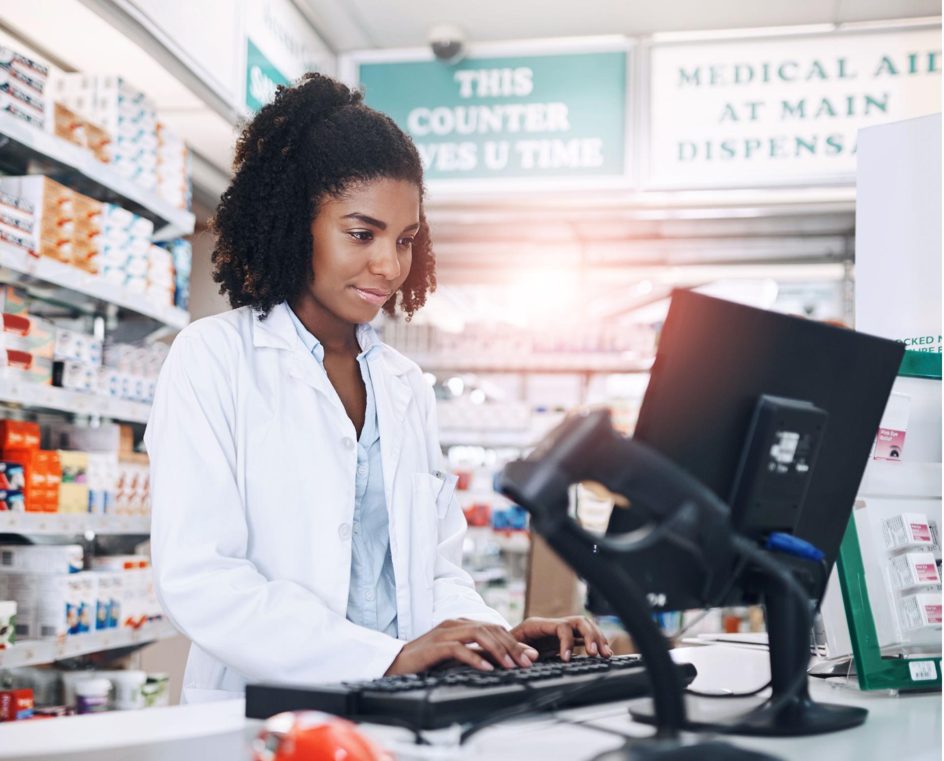 Farmacia, atención médica y mujer negra con medicinas, trabajo e inventario con teclado en la tienda para pastillas. Tienda, persona y computadora para el procesamiento de la receta, en línea y la escritura del empleado en el trabajo